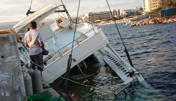 بالصور….. انتشال قارب سياحي قبل غرقه في نادي اليخوت الملكي بالعقبة